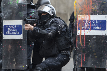 Un agente de Mossos dispara un proyectil de foam durante una protesta en Barcelona. 