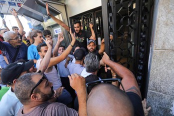 Gente congregada ante una sucursal del Blom Bank en Beirut, este 16 de setiembre, para expresar su apoyo a un depositante que irrumpió en el banco exigiendo retirar sus ahorros.
