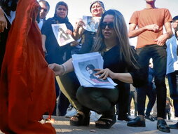 Una mujer kurda quema su hiyab como protesta.