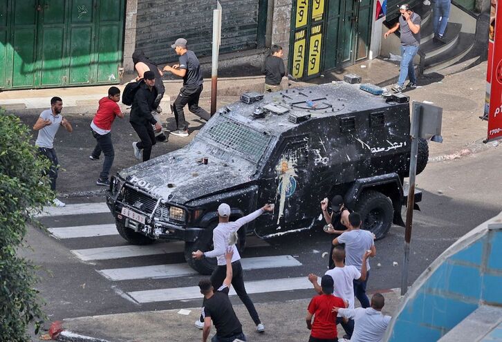 Jóvenes lanzann piedras y pintura contra un vehículo de las fuerzas de la Autoridad Palestina en Nablús.