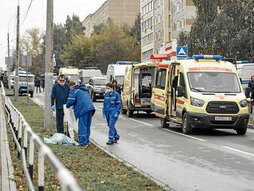 Médicos cubren un cuerpo cerca de la escuela.