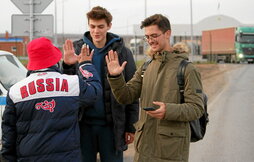 Un voluntario recibe a dos jóvenes rusos en Kazajistán, que, como Georgia o Armenia, recibe a miles desde el anuncio de la movilización.