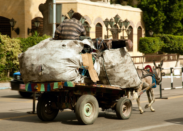 Un zabbaleen recorre las calles de El Cairo con su carro repleto de residuos.