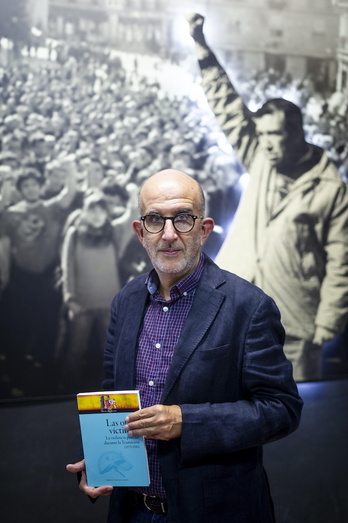 David Ballester, con su libro ante una foto del 3 de Marzo en Gasteiz.