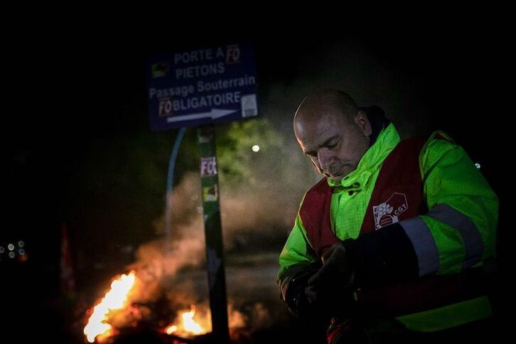 Huelguista ante una barricada con fuego a la entrada de la planta de Port-Jérôme-Gravenchon, donde arrancará la orden de movilización de personal lanzada por el Gobierno.