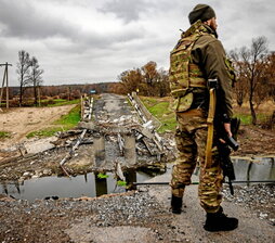 Un soldado ucraniano ante un puente destruido.