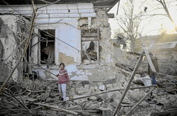 Una mujer asiste al desescombro de su vivienda, destrozada por los bombardeos.