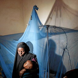 Una mujer somalí, con su hijo en un centro médico.