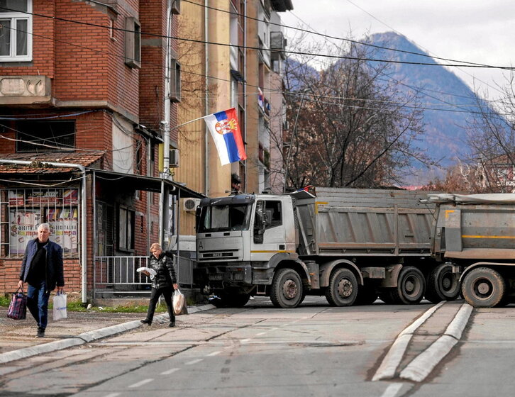 Peatones, junto a una barricada en Mitrovica, en el norte de Kosovo.