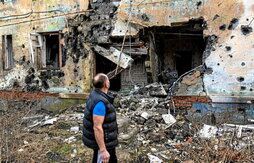 Un hombre contempla los daños de los bombardeos sobre un edificio en Izium.