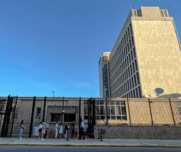 Varias personas esperan entrar en la Embajada.