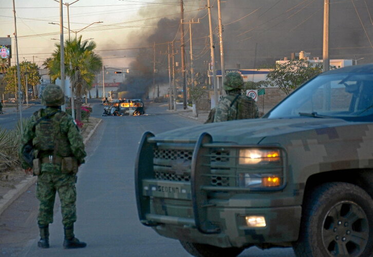 Soldados mexicanos, cerca de vehículos en llamas durante la operación en Culiacán.