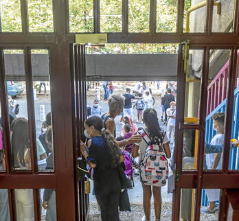 Unos niños entran a una escuela.