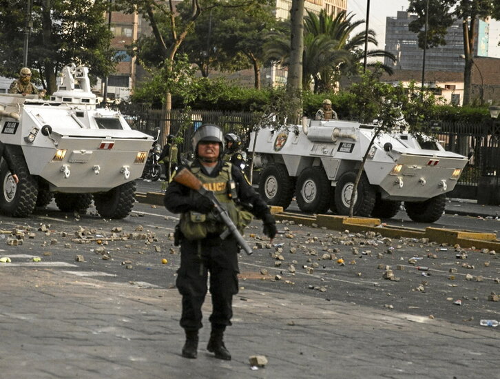 Dos tanquetas de Ejército y un policía, durante los disturbio en Lima.