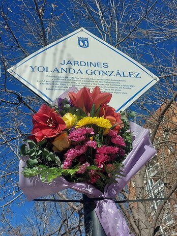 Flores en la placa de la plaza dedicada a Yolanda González en Aluche.