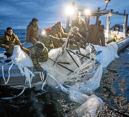 Miembros de la Marina estadounidense recogen los restos del primer objeto derribado.