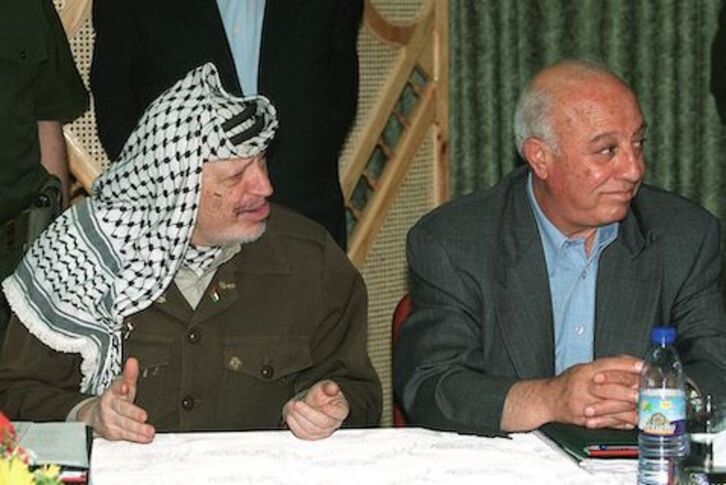 Jassir Arafat, ezkerrean, keinuka, 2000. urtean Gazan egindako bilera batean, ondoan Ahmed Qurei legegintzaldiko kontseiluko bozeramailea duela.