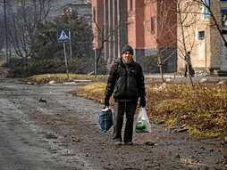 Un hombre camina por una calle de Bajmut.