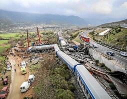 Policía y equipos de emergencia buscan entre los restos de los vagones aplastados tras el accidente ferroviario de Tempe.