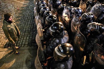 Un manifestante frente a decenas de policías durante unas protestas en Georgia.