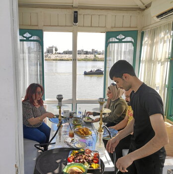 Lujain al Habi,  a la izquierda, disfruta de las vistas al Tigris junto a su hermana y cuñado.