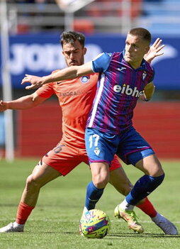 Corpas protege el balón encimado por Pampín.