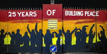 Las puertas de Lanark Way, entre las zonas republicana y lealista de Belfast, fueron pintadas antes del 25 aniversario del Acuerdo de Viernes Santo. A la derecha, un muro que separa ambas comunidades.