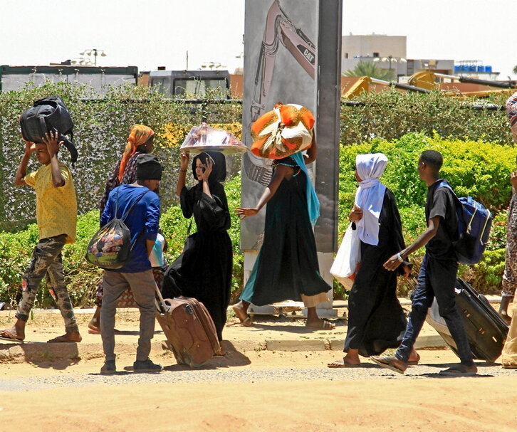 Varias personas huyen de los combates de Jartum hacia el sur.
