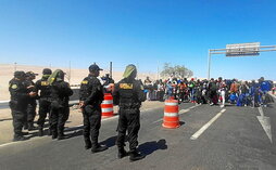 Policías peruanos impiden el cruce la frontera a decenas de migantes.