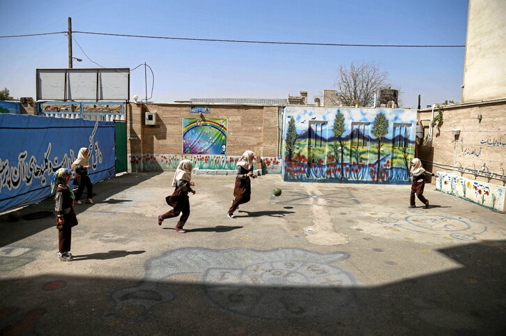 Unas niñas juegas en el patio de un colegio en Teherán.