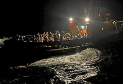 Un remolcador transporta a un grupo de evacuados a un barco saudí.