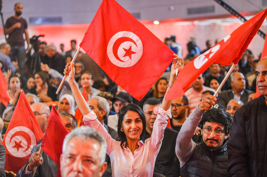 Participantes ondean banderas tunecinas durante una manifestación celebrada por la Unión General Tunecina del Trabajo el Primero de Mayo en Túnez.