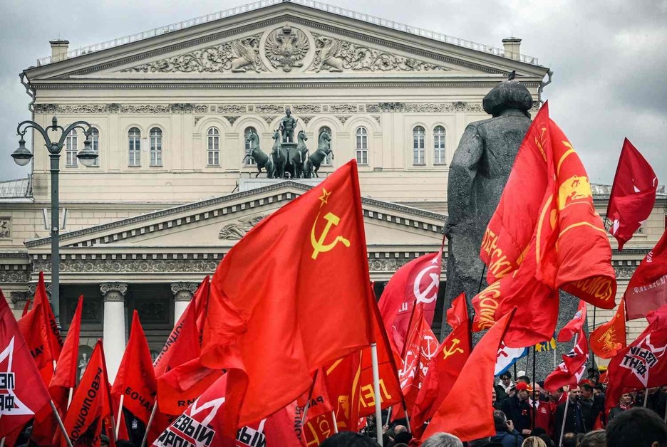 Simpatizantes comunistas rusos sostienen banderas mientras asisten a una concentración por el Primero de Mayo frente al Teatro Bolshói de Moscú.