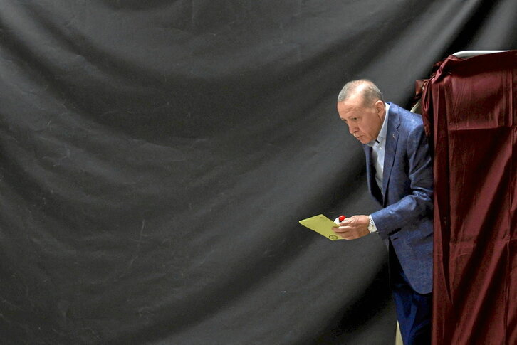 El presidente turco, saliendo de la cabina de voto.