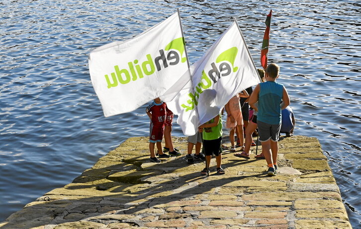 Varios niños juegan en Donostia con banderolas de EH Bildu, coalición por la que se presentan los 44 candidatos señalados.