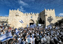 Los manifestantes ondean banderas israelíes frente a la Puerta de Damasco de la Ciudad Vieja de Jerusalén.