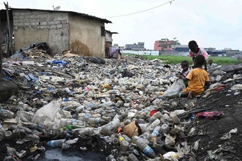 Unos niños recogen envases plásticos el pasado día 25 de mayo en Anyama, cerca de Abidjan, la ciudad más grande de Costa del Marfil, país anfitrión del Día Mundial del Medio Ambiente.