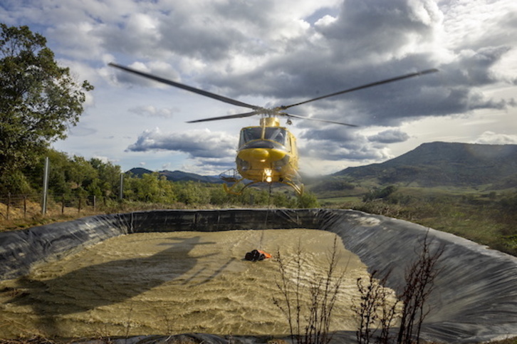 Un helicóptero del Gobierno español carga agua para un incendio en Balmaseda.