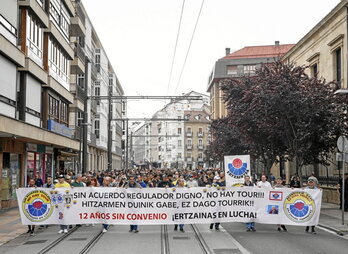 Manifestación de los agentes de la Ertzaintza y detalle de la pancarta con menciones a la directora de recursos humanos del Deparatamento de Seguridad.