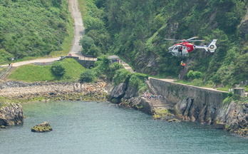 El helicóptero de la Ertzaintza, a la altura de la bocana del puerto de Pasaia, con el primero de los cuerpos hallados.