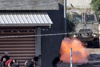 Un artefacto explota ante un blindado del Ejército israelí.