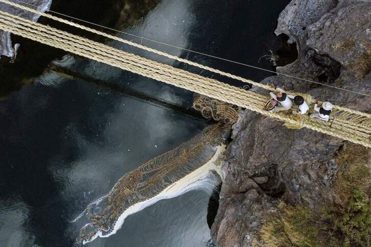 Vista aérea de personas de diferentes comunidades participan en la renovación anual del puente de cuerda Q'eswachaka.