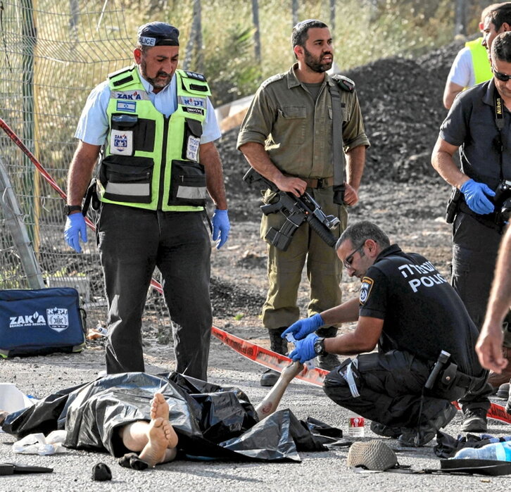 Policías israelíes examinan un cadáver.