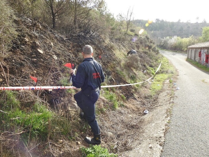 Un agente de la Policía Foral inspecciona el punto de origen del fuego en el monte Ezkaba en marzo.
