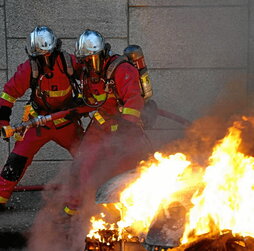Bomberos extinguen un coche incendiado, el martes por la noche en Nanterre.