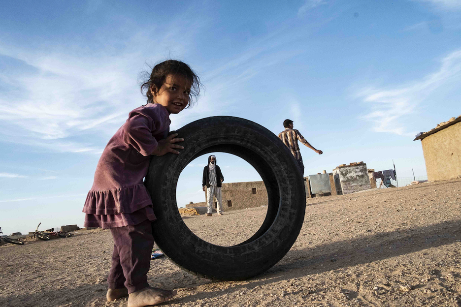 Los niños de Auserd no tienen juguetes, excepto una pelota de fútbol. En la imagen una niña jugando con una rueda vieja en el barrio de La Güera.