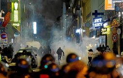 Manifestariak, korrika ihesi, Parisen, gas negar-eragilez oldartu zaizkien polizien aurrean.