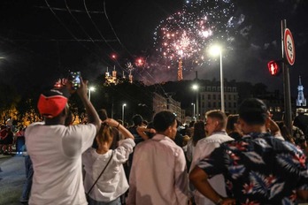 Viandantes contemplan los fuegos del 14 de julio en París.