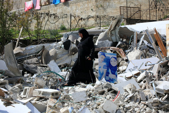 Una mujer camino entre los escombros de una vivienda palestina destruida por el Ejército israelí en el barrio de Jabal Mukaber, también en Jerusalén Este.