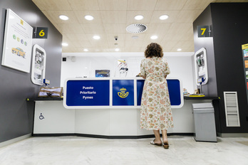 Una mujer es atendida en una oficina de Correos en Madrid.